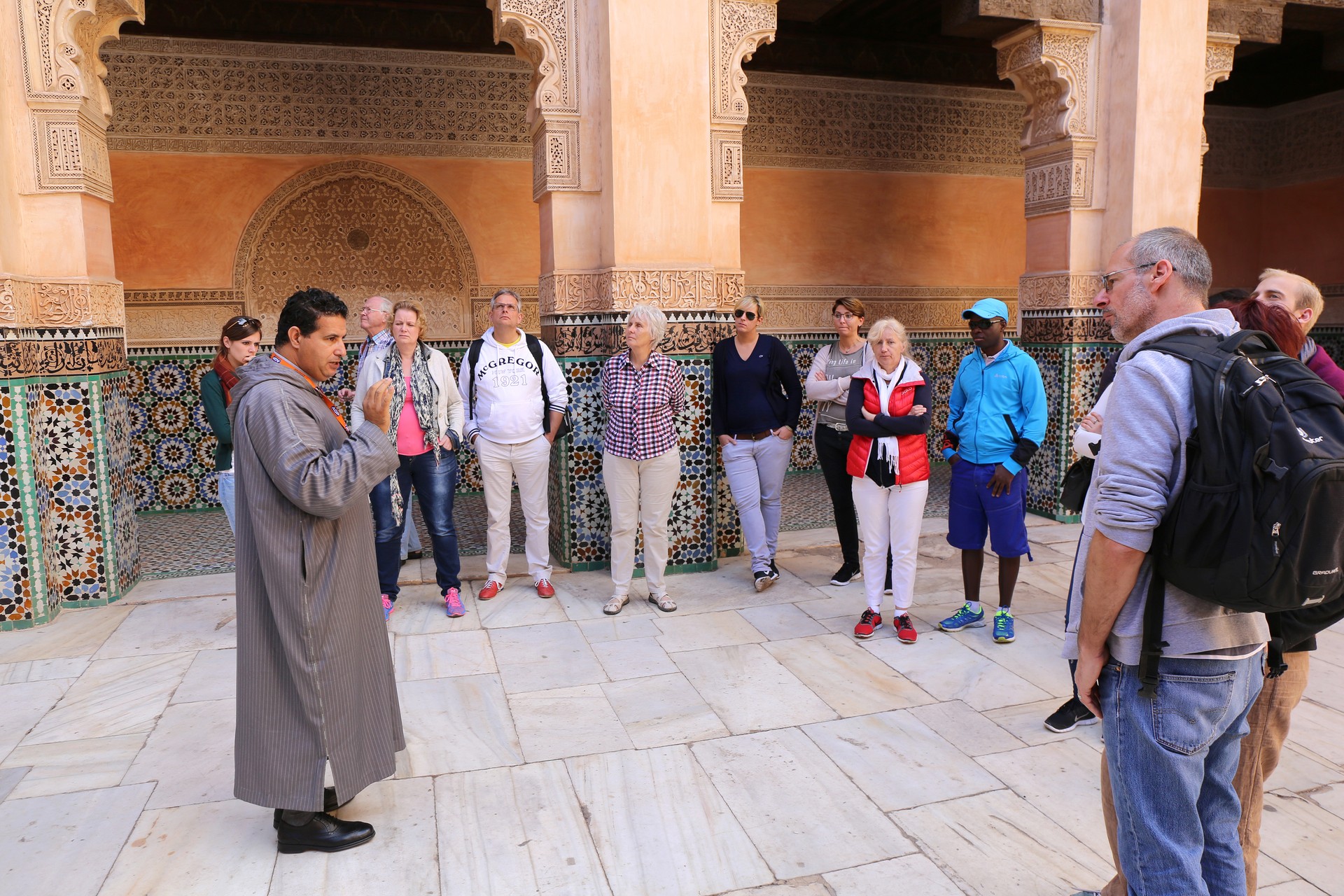 Unidentified Moroccan Tourist Guide giving information about palace to German Tourists in Marrakesh, Morocco