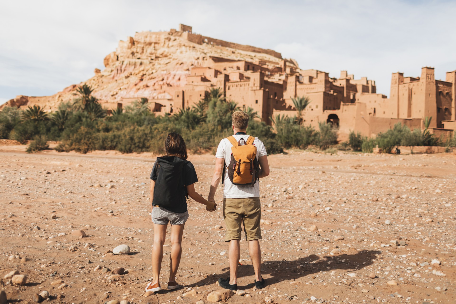 Couple of backpacker travelers on background Ait Ben Haddou ksar in Ouarzazate. Welcome to Morocco. Travel concept. Popular landmark.